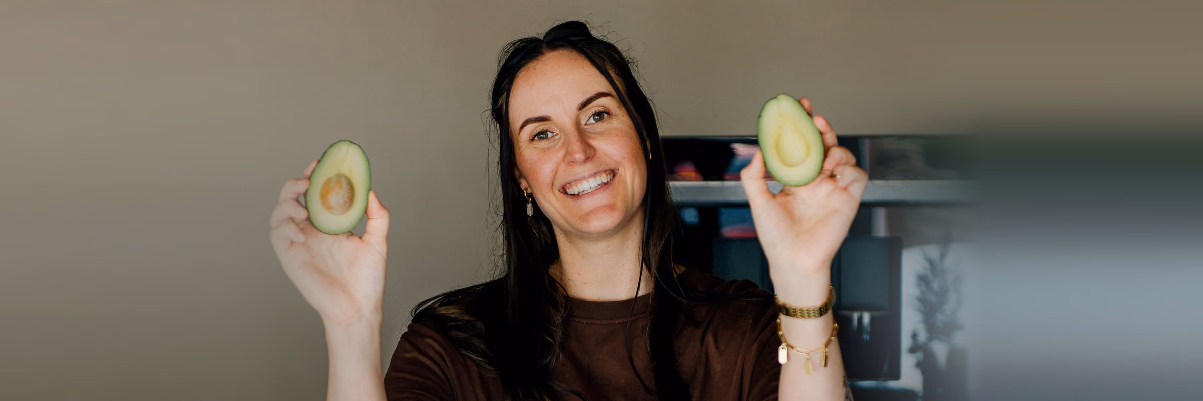 Niké met twee halve avocado's in de keuken